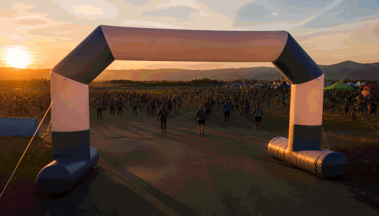 Custom inflatable arch installed at an outdoor event entrance at dusk